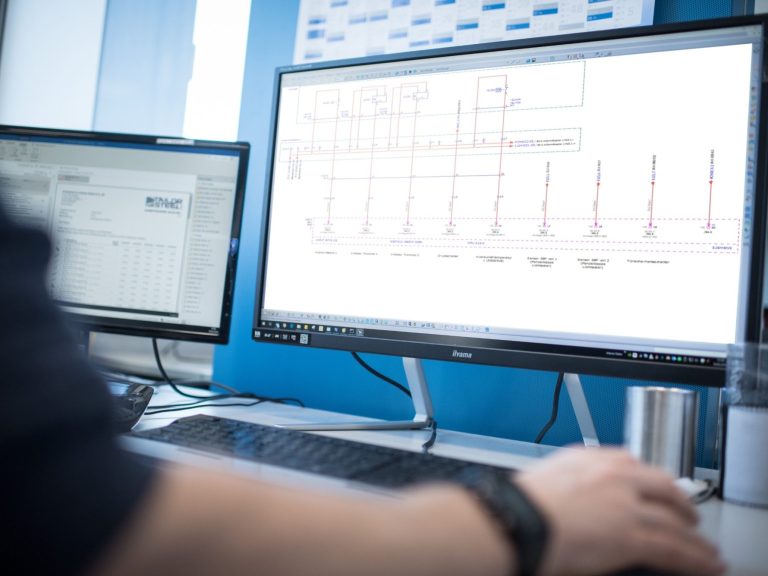 Leistungen im Ueberblick Person arbeitet an einem Computer mit CAD-Software für technische Zeichnungen.